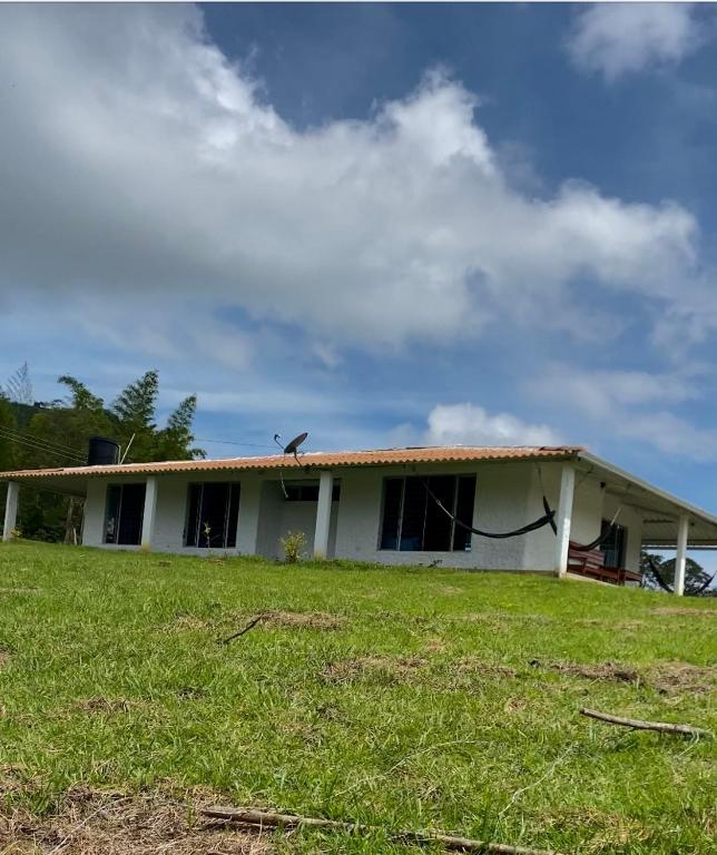 une maison blanche avec un oiseau assis au-dessus dans l'établissement Finca Villa Anita Moniquirá Boyacá, à Moniquirá