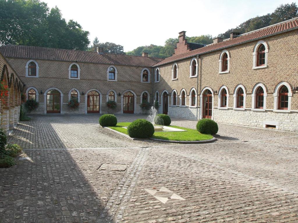 a courtyard of a building with a brick driveway at Hôtel - Ferme du Château d'Ahin in Huy