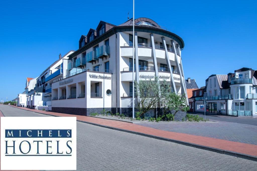 ein weißes Gebäude mit einem Schild, das Mitzels Hotels liest in der Unterkunft Michels Villa Nordsee in Norderney