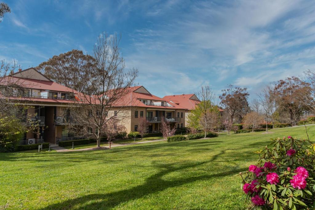 una casa grande con un patio con flores en Leisure Inn Spires, en Leura