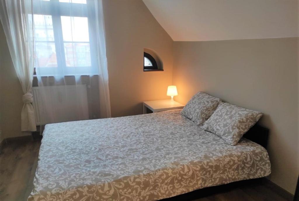 um quarto com uma cama e uma janela em Rynek 10 em Poznań