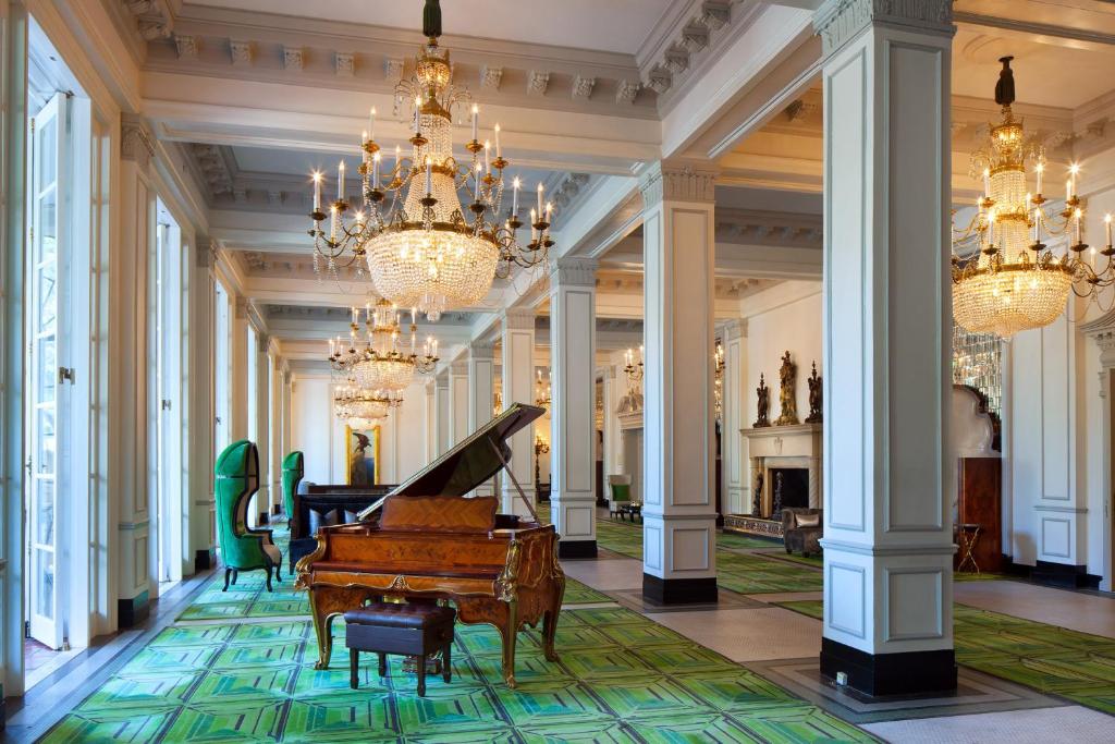 um grande salão com um piano e lustres em The St. Anthony, a Luxury Collection Hotel, San Antonio em San Antonio