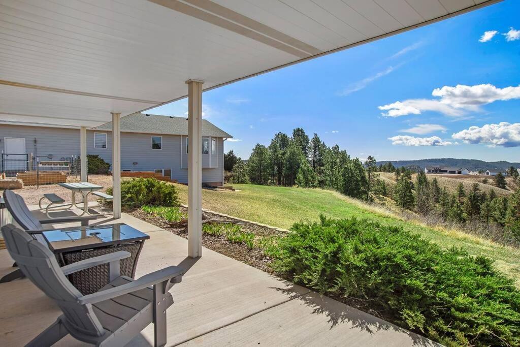 un patio con mesa y sillas en un porche en Unique Barn Stay Close to The Hills en Rapid City