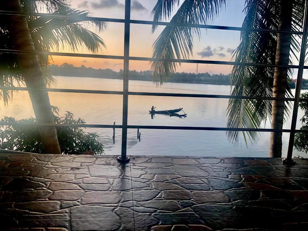 une personne dans un bateau à travers une fenêtre dans l'établissement Lagoon Breeze Resort, à Batticaloa