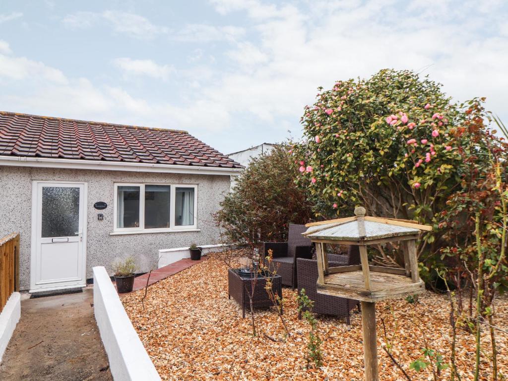 a house with a garden with a bird feeder at Sandyfeet in Camborne