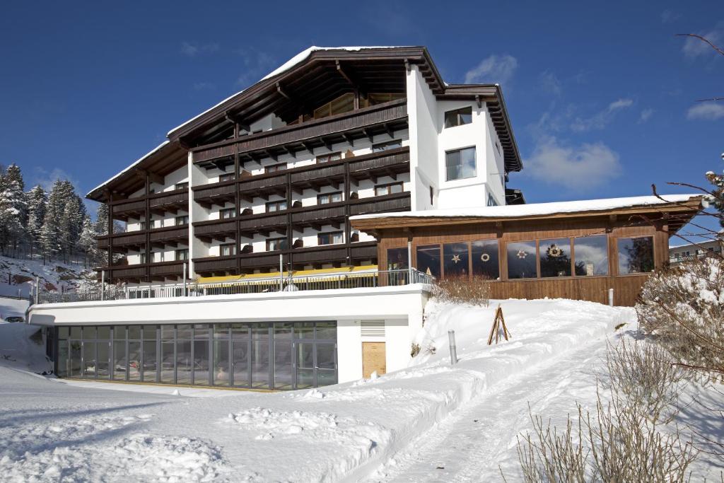 un edificio en la nieve delante en Hotel Achentalerhof en Achenkirch