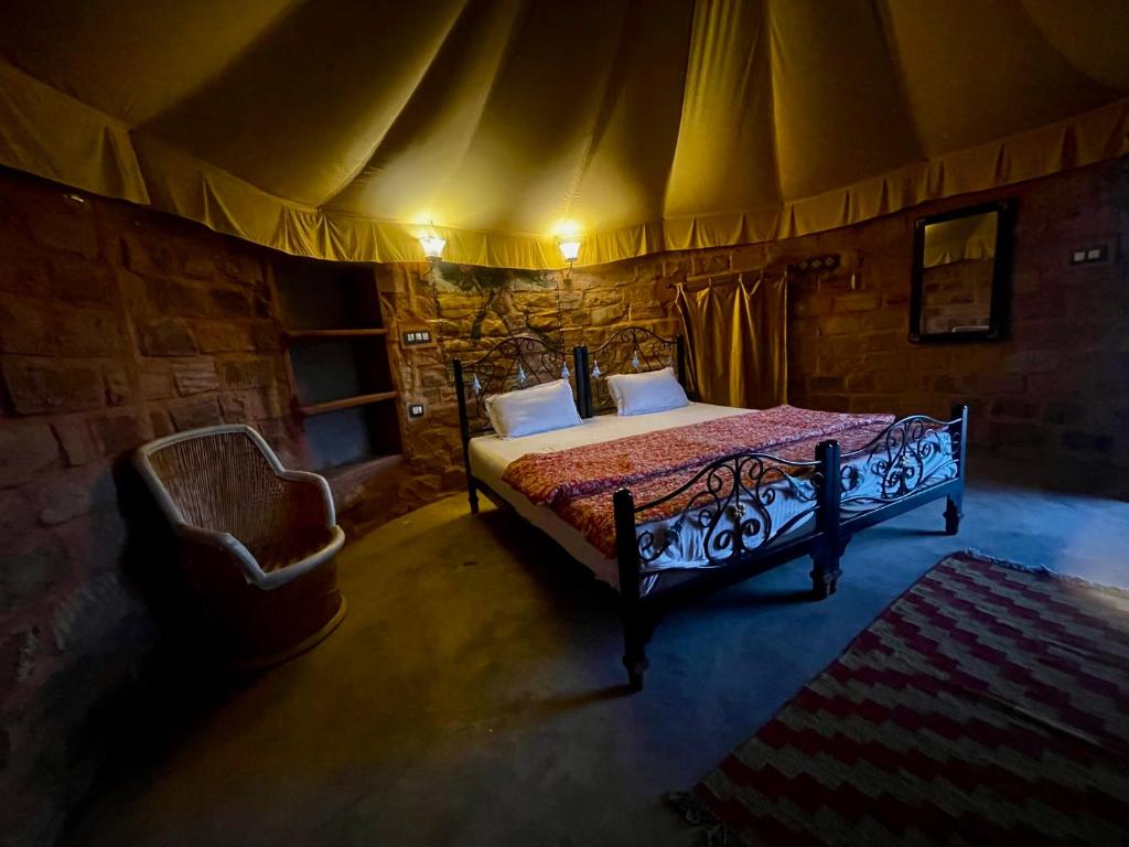 een slaapkamer met een bed en een stoel in een tent bij Pukhraj Garh- A Heritage Homestay in Jodhpur