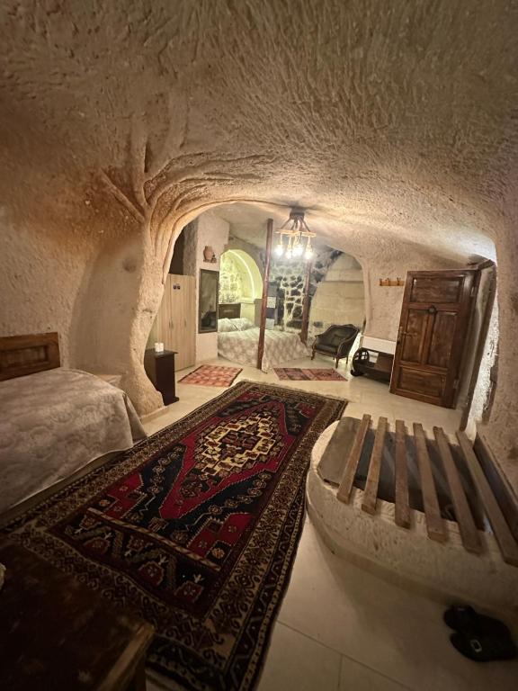 een slaapkamer met een bed, een bank en een tapijt bij Uchisar Cave House in Uchisar