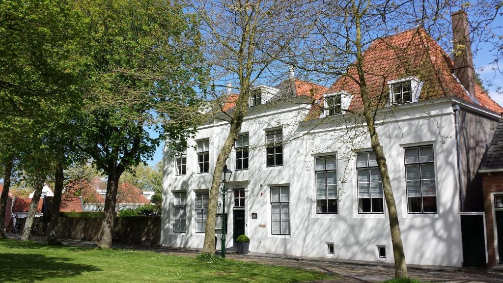 uma casa branca com árvores em frente em Bed en Brood - Veere em Veere