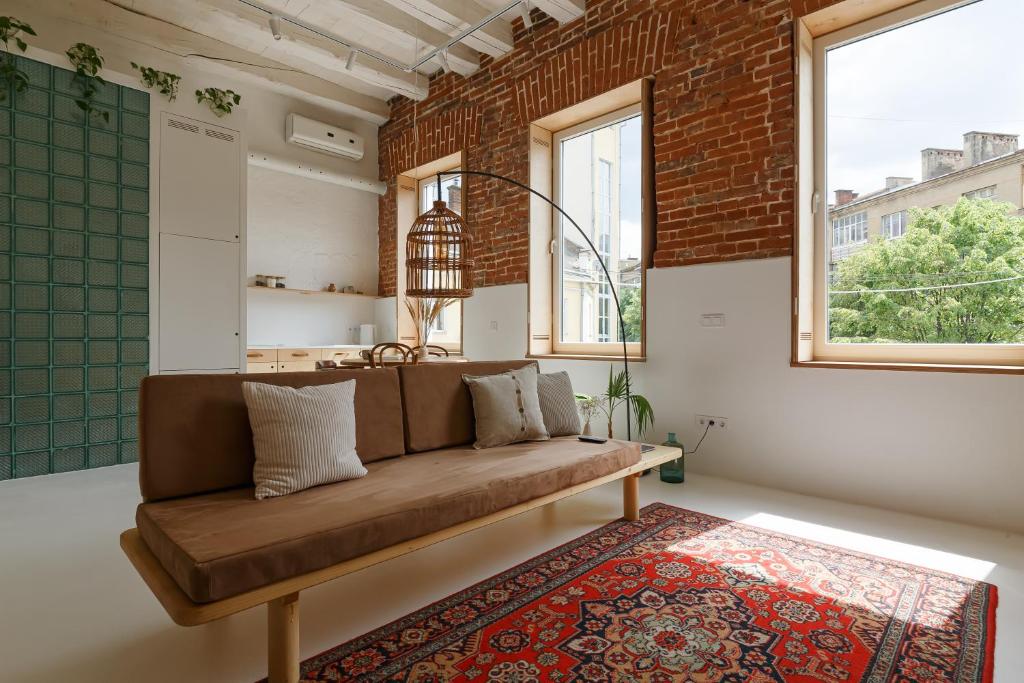 sala de estar con sofá marrón y pared de ladrillo en Loft Apartment en Ivano-Frankivsk