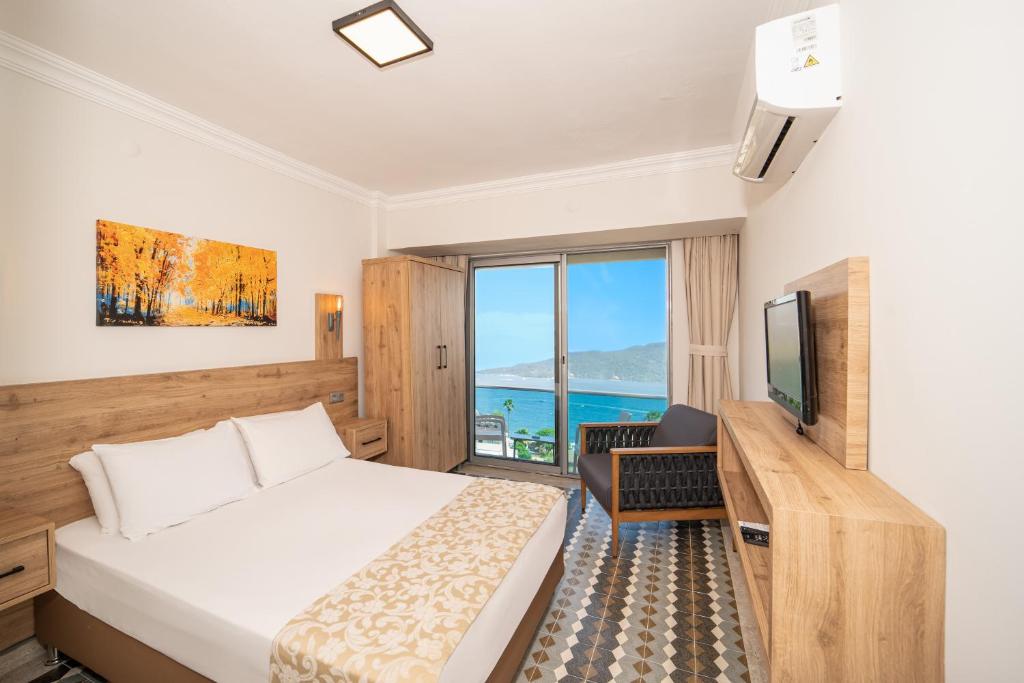 a hotel room with a bed and a television at Moda Beach Hotel in Marmaris