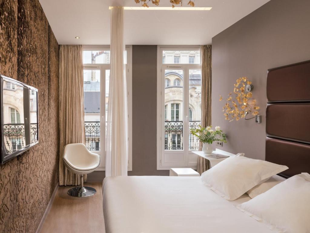 Rúm í herbergi á Legend Hôtel Paris