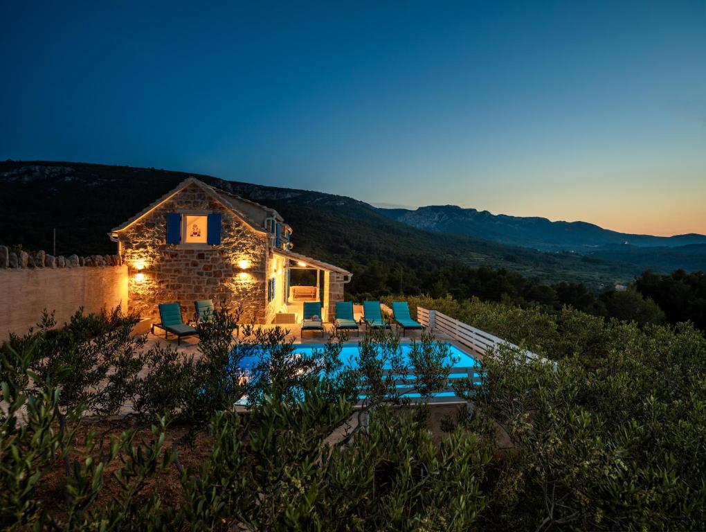 a villa with a swimming pool at night at Villa Starry Sky ,Hvar in Jelsa