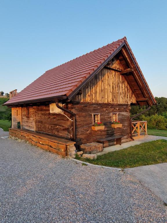 Cabaña de madera con techo rojo en el lateral en Vineyard cottage Vinska grajska kašča en Mirna