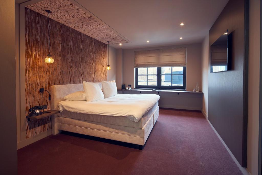 Tempat tidur dalam kamar di The Yard hotel Noordkade