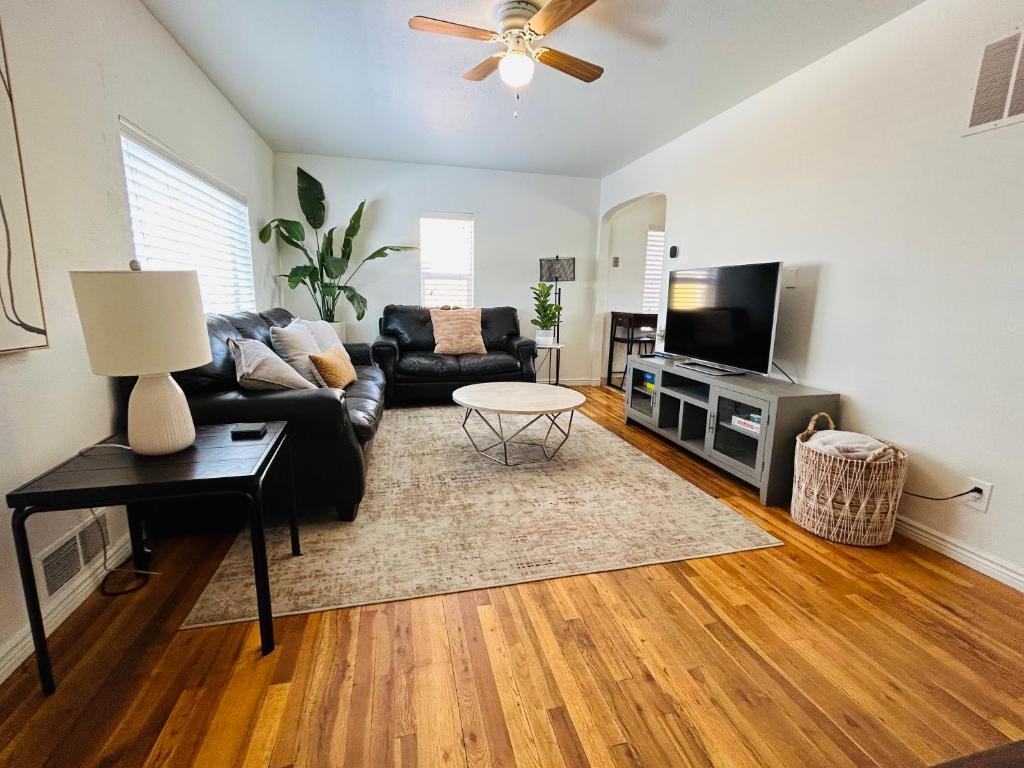 sala de estar con sofá negro y TV de pantalla plana en Home Sweet Idahome, feels like home with all the decor you wish you could afford King bed in master, fully fenced dog friendly yard, a few blocks from BSU and downtown Boise, Your perfect stay! en Boise