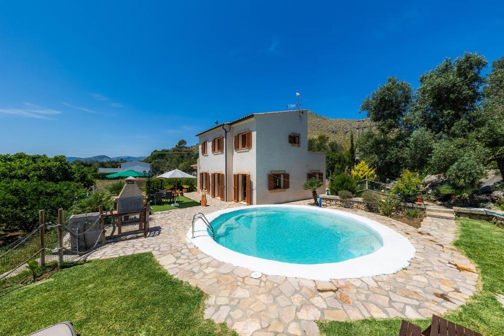 een achtertuin met een zwembad en een huis bij Villa Maria in Port de Pollença