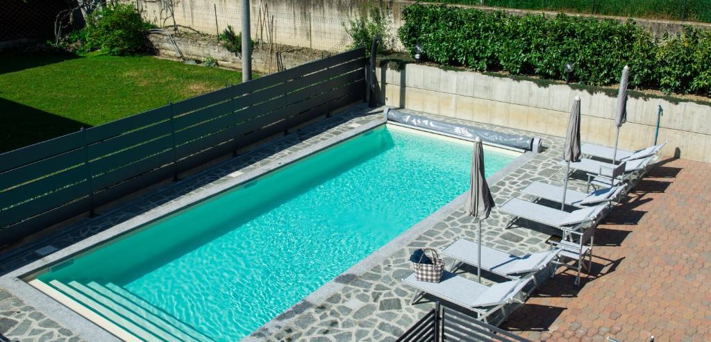 une piscine avec des chaises longues et une piscine dans l'établissement B&B Marzia, à Alba