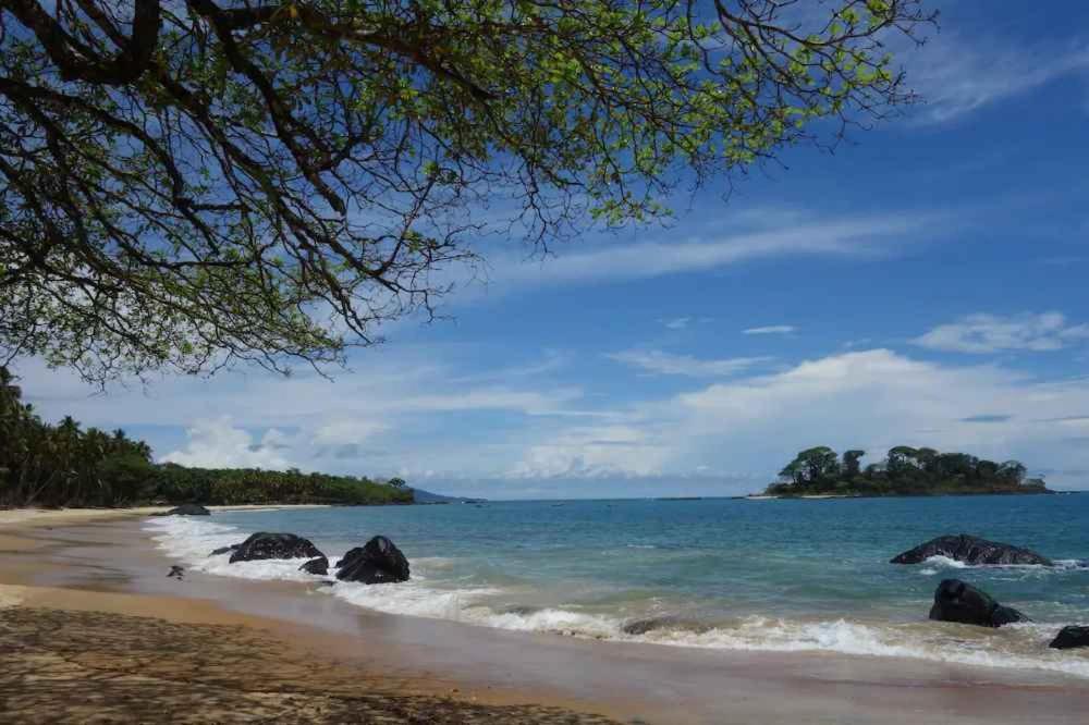 uma vista para uma praia com pedras na água em Robinson's Hut em Bure Town