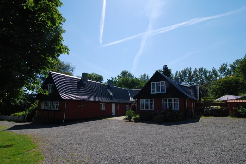 una casa roja con una entrada delante de ella en Pyttegården Apartments, en Gudhjem