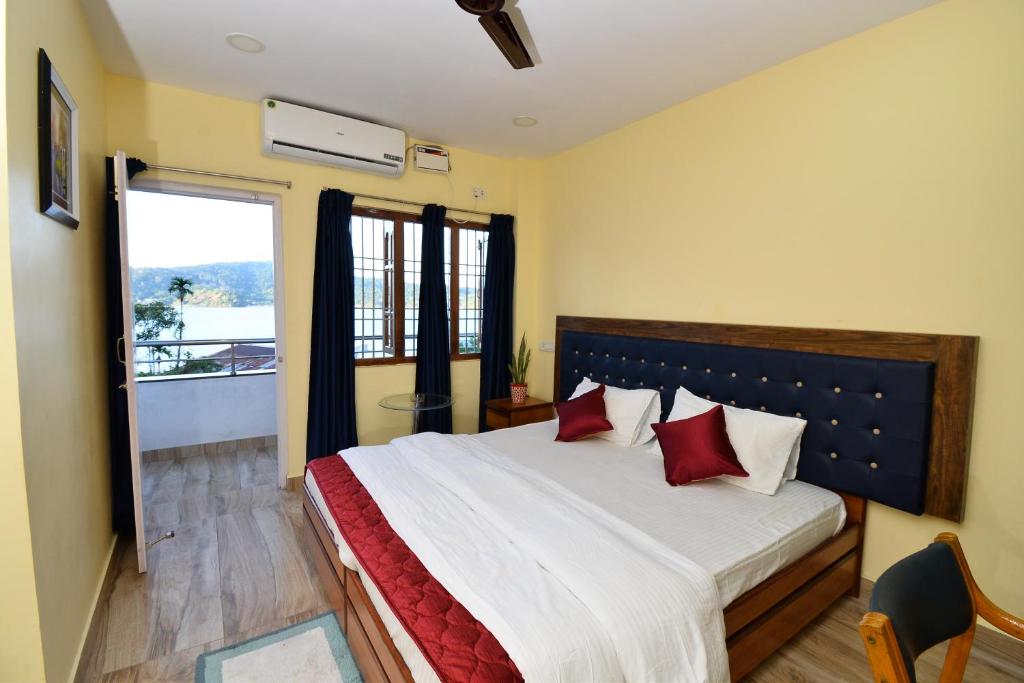 um quarto com uma cama grande e almofadas vermelhas em The Hook BnB, Port Blair em Haddo