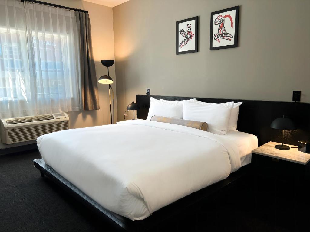 uma grande cama branca num quarto com uma janela em Edgewater Hotel em Whitehorse