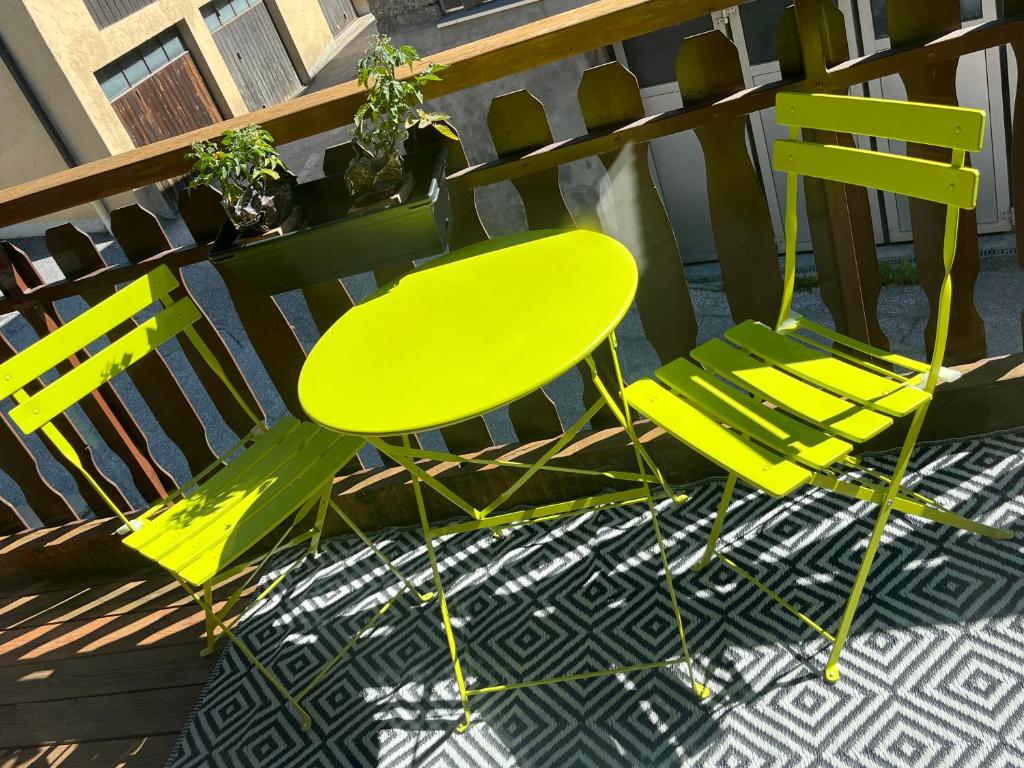 two yellow chairs and a table on a patio at Les coeurs brisés in Crans-Montana