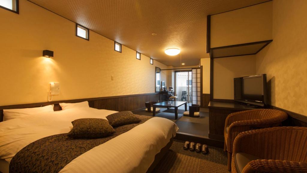 una camera con letto e TV a schermo piatto di Beauty&Spa Resort IZU 頬杖の刻 a Izu