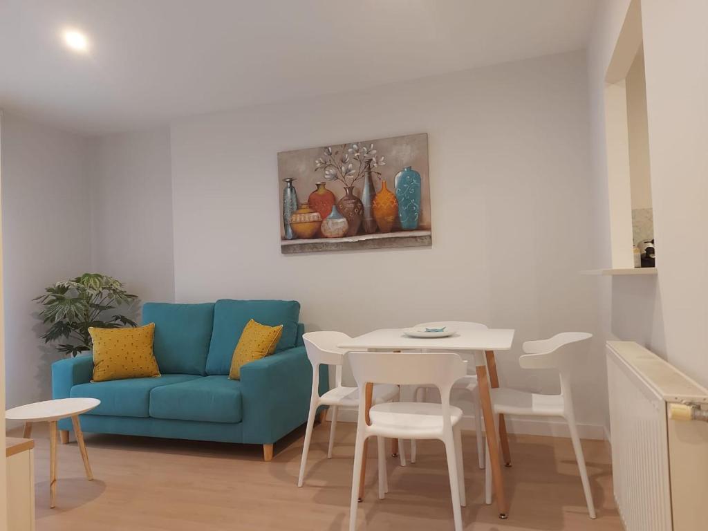 uma sala de estar com um sofá azul e uma mesa em Apartamento Silleda Confort em Silleda