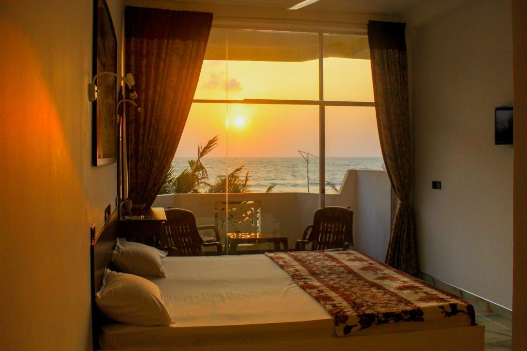 um quarto com uma cama e vista para o oceano em Hotel Coconut Bay em Kalutara