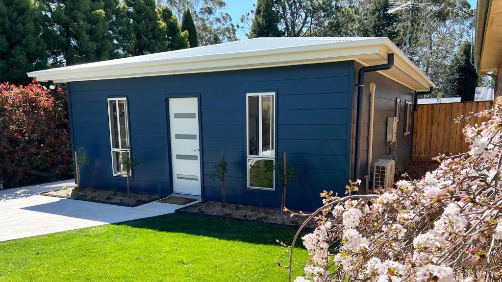 una casetta blu in un giardino di Honey Fig Cottage, Bowral a Bowral