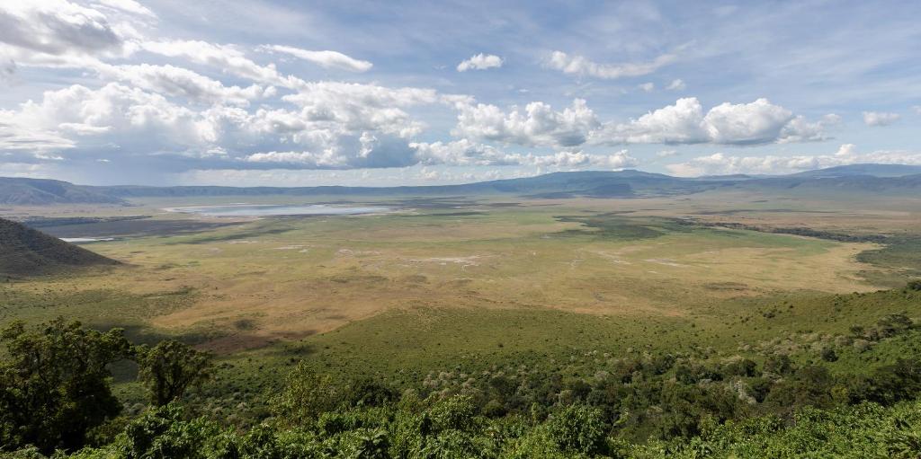 Ngorongoro Lodge member of Meliá Collection في نجورونجورو: اطلالة جوية على وادي مع نهر وجبال