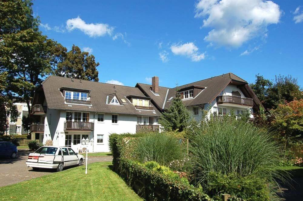 un coche blanco estacionado frente a una casa en Haus Windrose Ferienwohnung Nr 16 en Niendorf