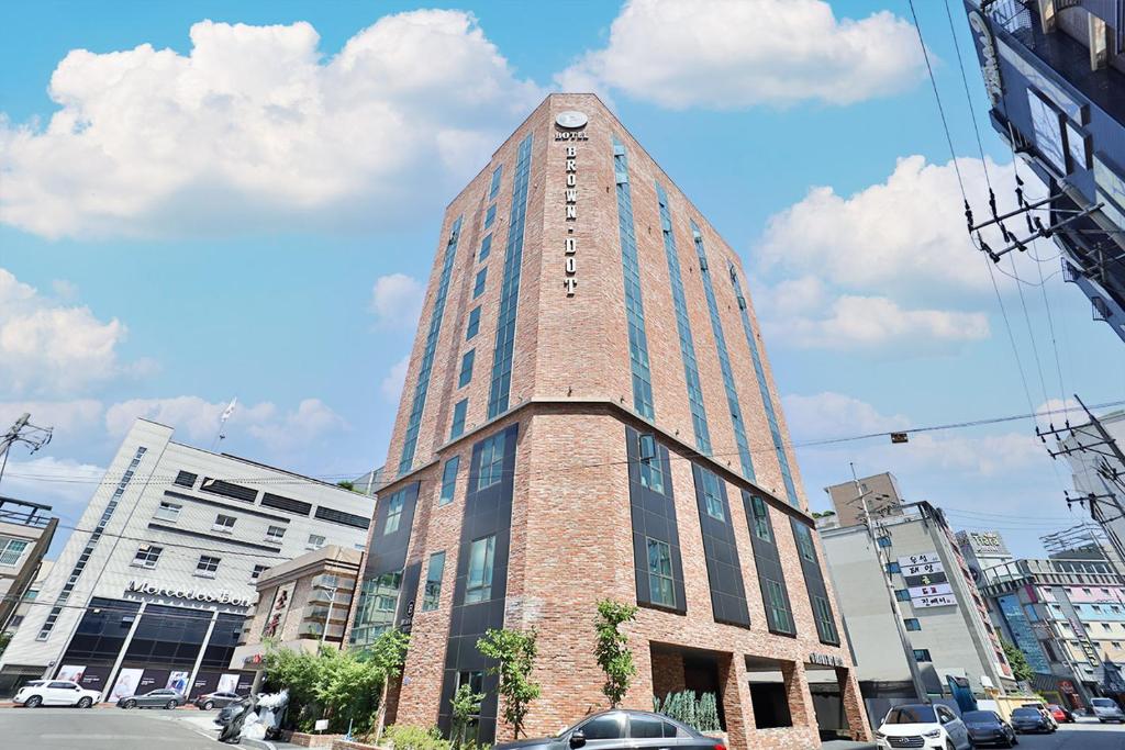 een hoog gebouw met een klok erop bij Brown Dot Hotel Ulsan Samsan in Ulsan