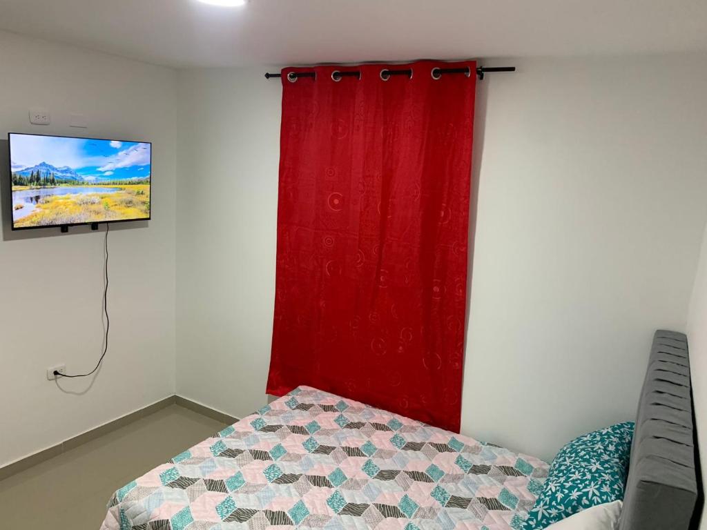 - une chambre avec un rideau rouge et un lit dans l'établissement APARTAMENTO EN VALLEDUPAR, à Valledupar