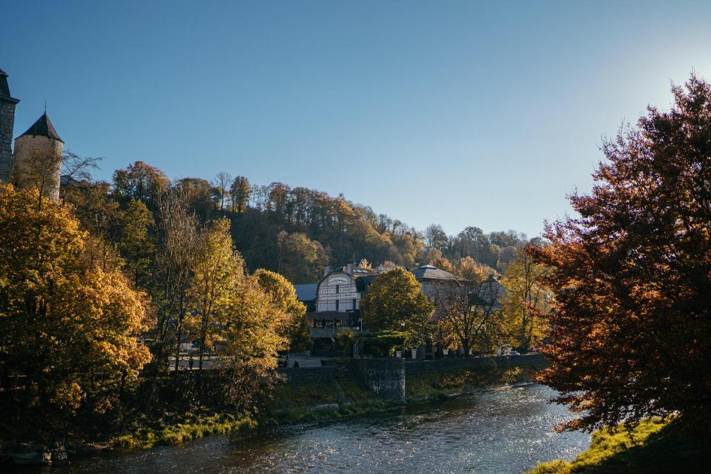 vistas a un río con una casa y árboles en Hotel Sanglier en Durbuy