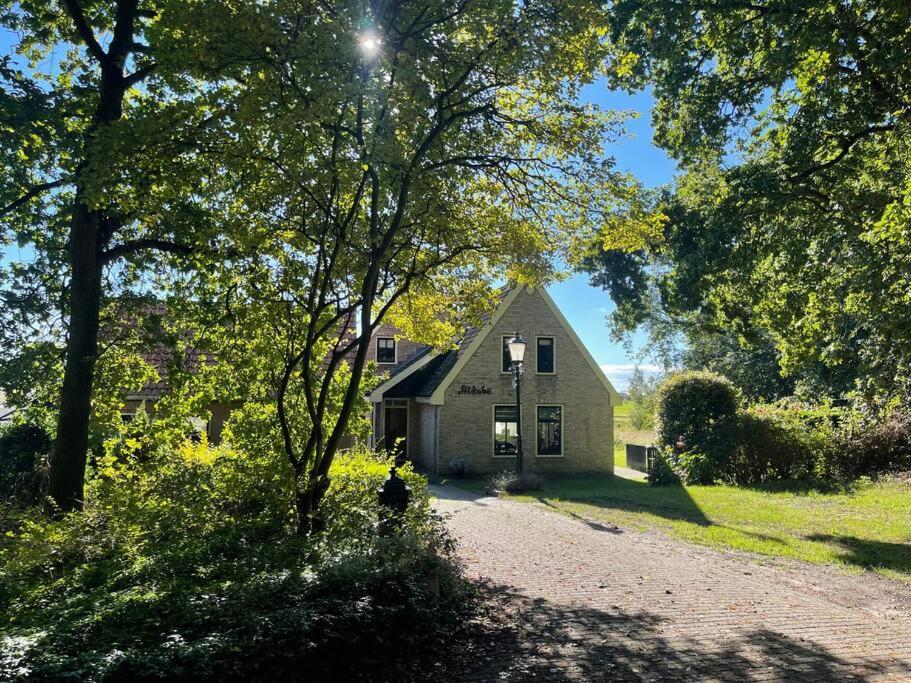 ein Haus inmitten eines Feldes mit Bäumen in der Unterkunft Vakantiehuis Aldubo in Den Burg