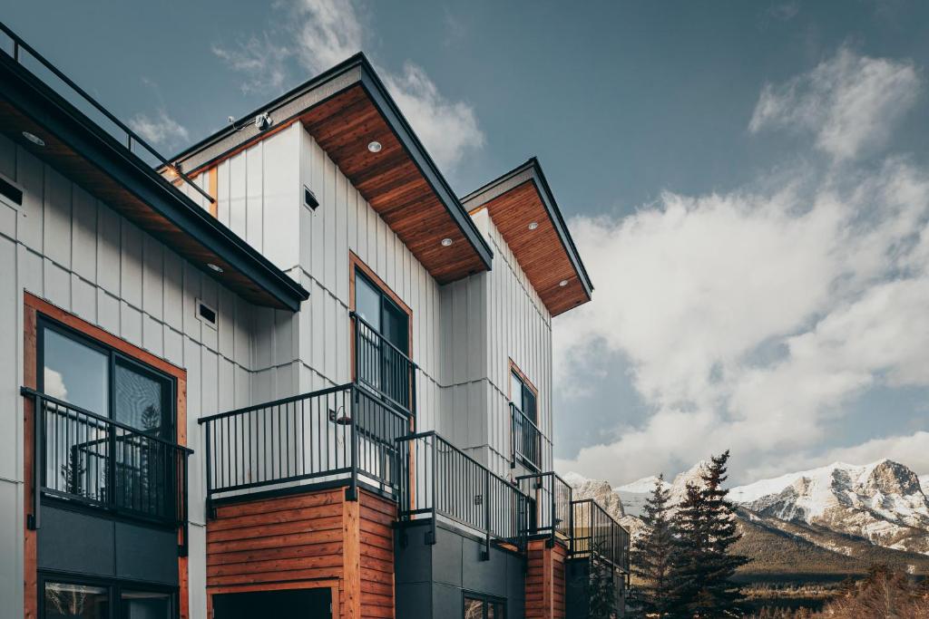 een huis met een balkon en bergen op de achtergrond bij Basecamp Suites Canmore in Canmore