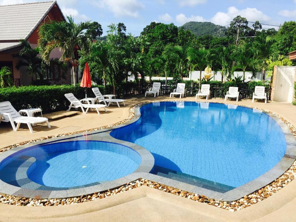 een zwembad met ligstoelen en stoelen eromheen bij Natural Samui Hotel in Bophut 