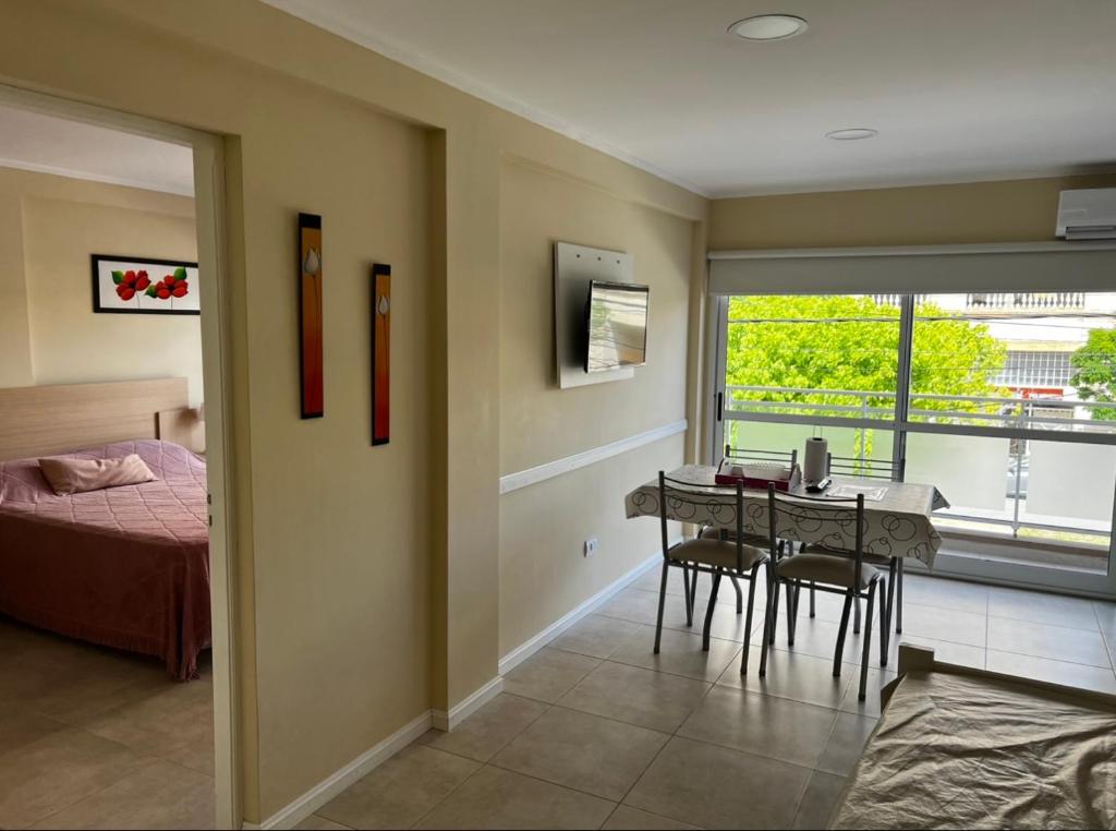 a room with a bed and a dining room with a table at Caracolas Departamentos in San Clemente del Tuyú