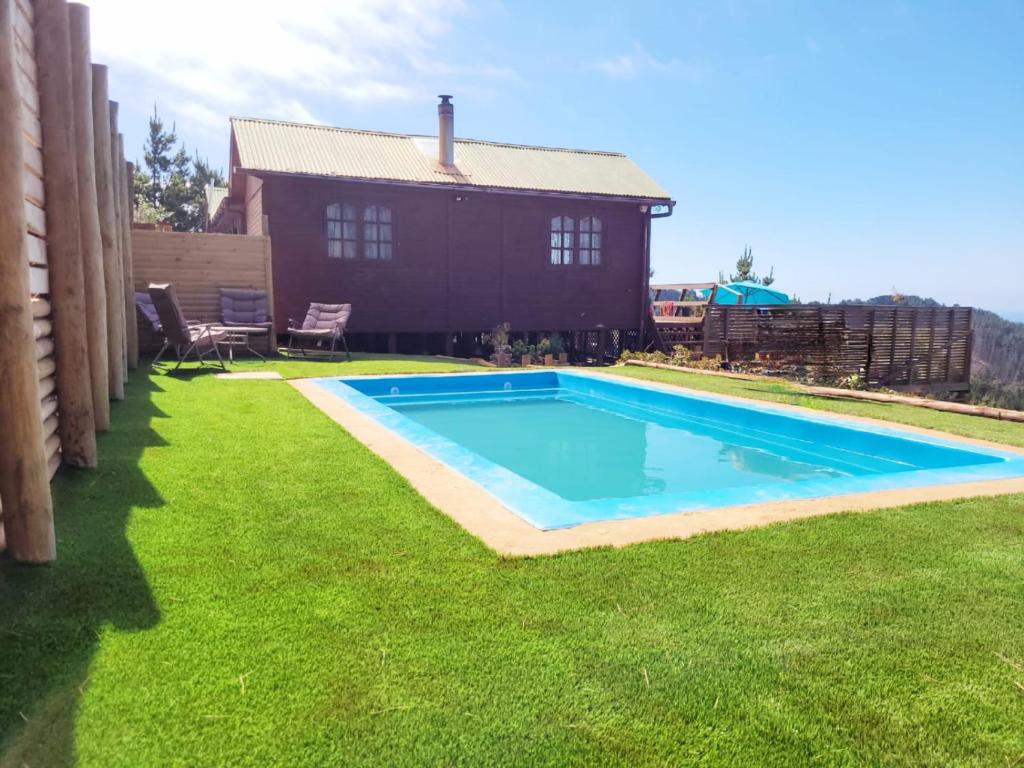 una piscina en un patio junto a una casa en Cabaña Punta Del Cerro, con Piscina, Tinaja caliente y vista al Mar en Valparaíso