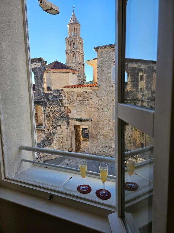 uma vista a partir de uma janela com dois copos de vinho em PIAC Luxury Suites em Split