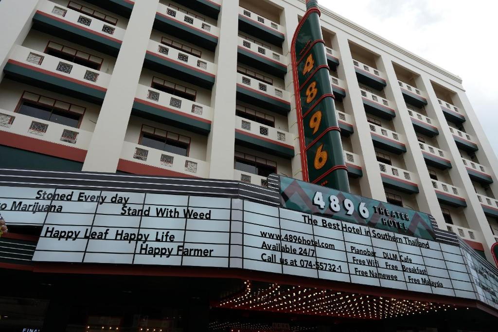 ein großes Gebäude mit einem Schild davor in der Unterkunft NW 4896 Theater Hotel in Ban Khlong Phruan