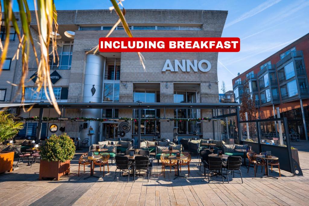 un restaurante con mesas y sillas frente a un edificio en Anno, en Almere