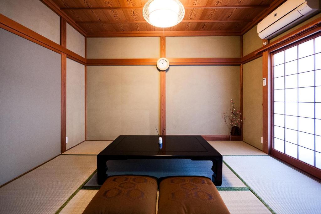 a room with a table and a clock on the wall at 海風〜nami no oto〜 in Himi