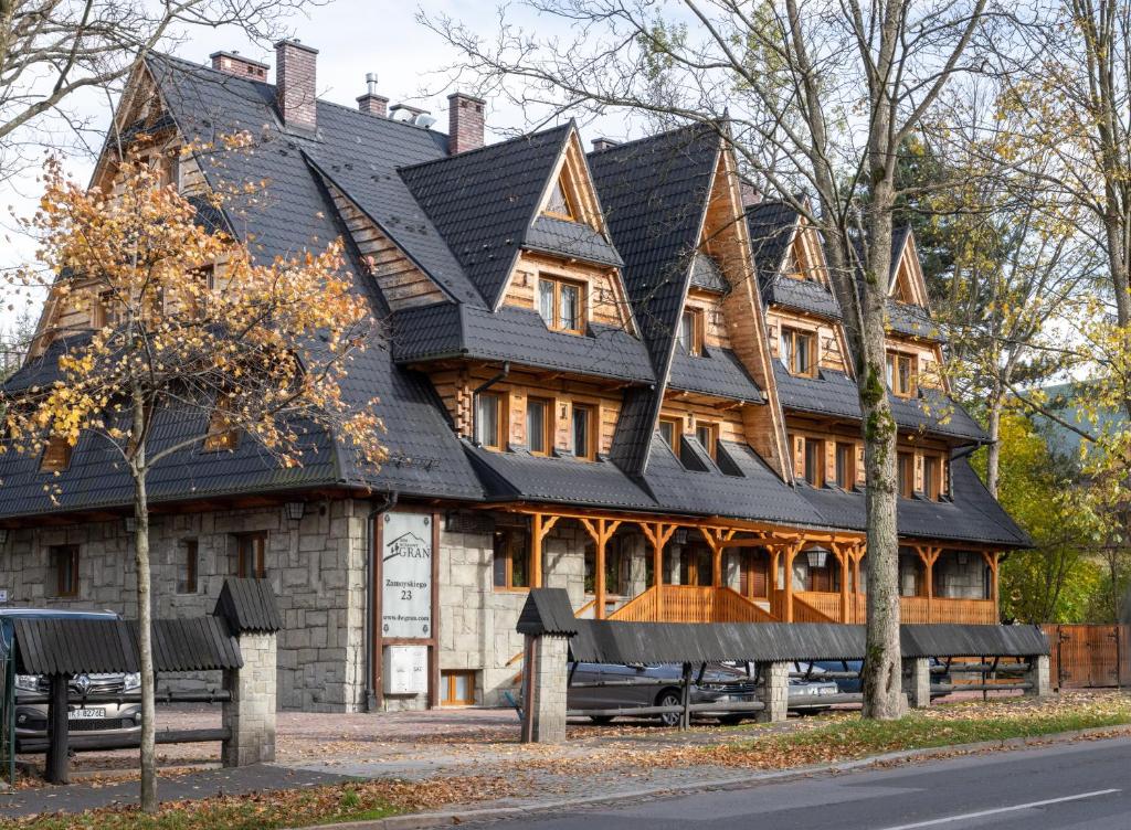 ein großes Holzhaus mit schwarzem Dach in der Unterkunft Dom Wczasowy Grań in Zakopane