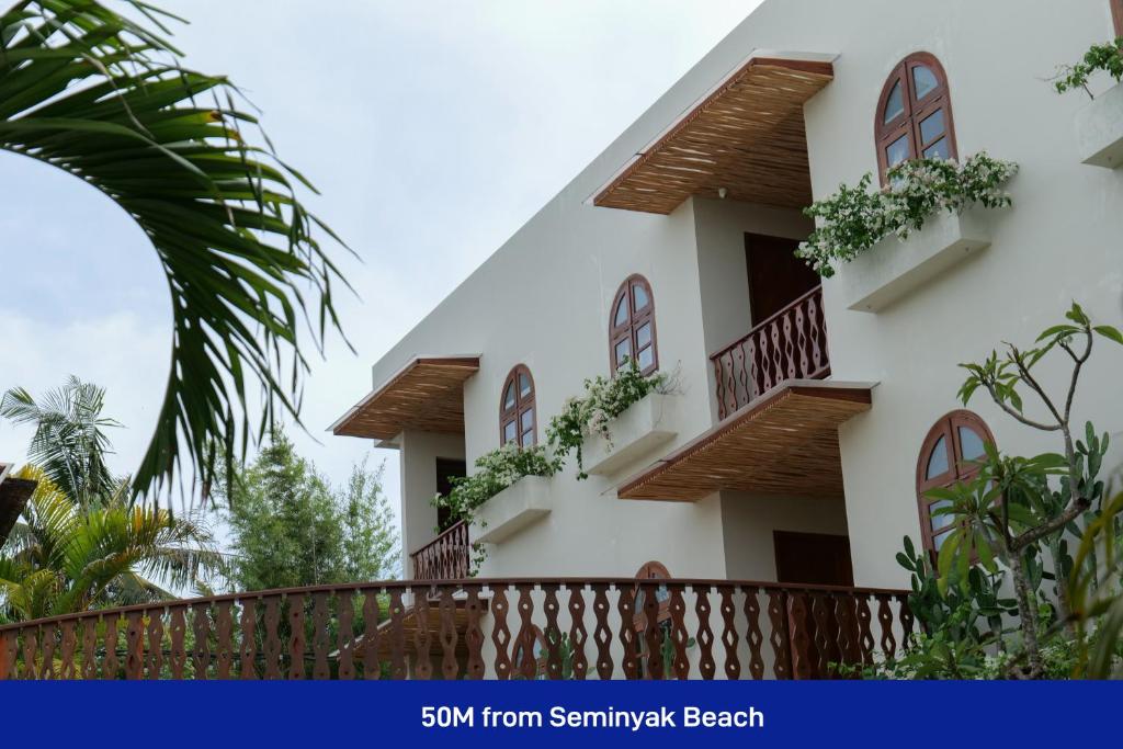 a building with balconies and plants on it at Kresna By The Sea By Kresna Hospitality in Seminyak