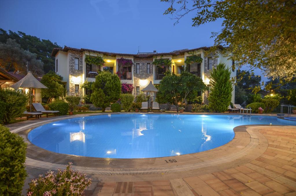 ein großer Pool vor einem Haus in der Unterkunft Olive Garden Apart Hotel in Göcek