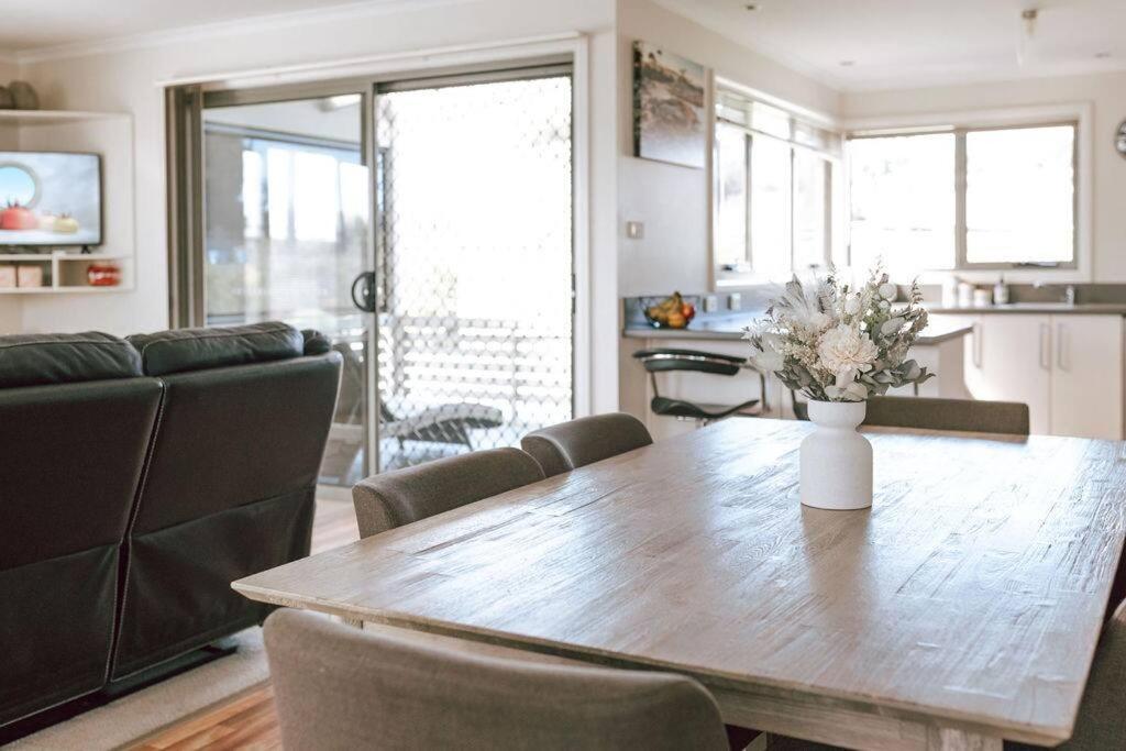 uma sala de estar com uma mesa de madeira e uma cozinha em Mara House - Space for Everyone em St Helens