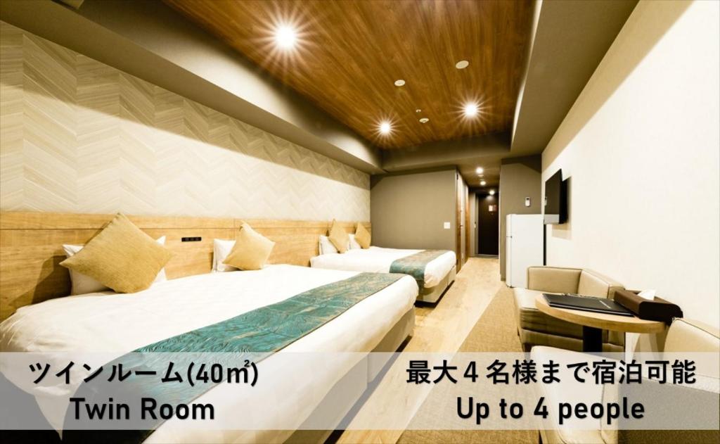 een hotelkamer met 2 bedden en een bank bij Takuto Hotel Osaka Shinsaibashi in Osaka